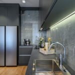 Modern trendy luxury dark gray kitchen closeup to worktop with marble wall